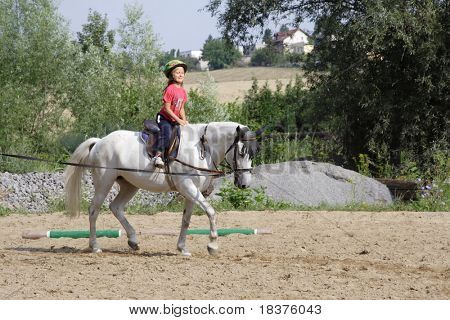 Ragazza giovane formazione sul cavallo bianco