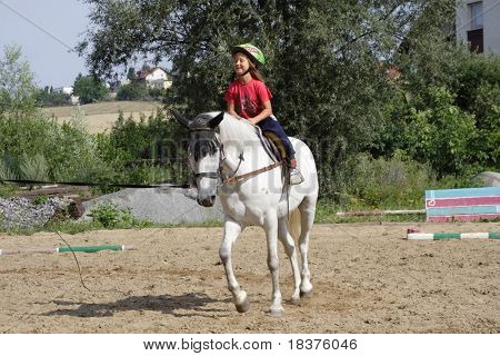 Ragazza giovane formazione sul cavallo bianco