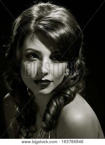 woman studio portrait in hollywood style light on black background. in black and white toning