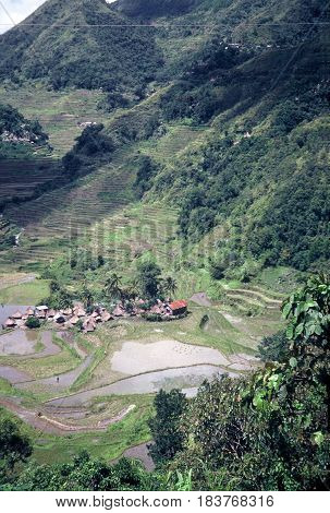 An Ifugao village stands at the bottom of a valley below the ancient  rice terraces, carved into the mountains, near the city of Banaue, Ifugao Province, in the Philippines.