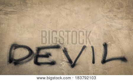 The word "devil" on grungy wall. Conceptual background
