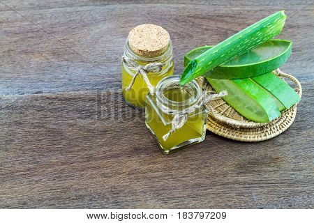 Fresh aloe vera gel with aloe vera essential oil on wooden table