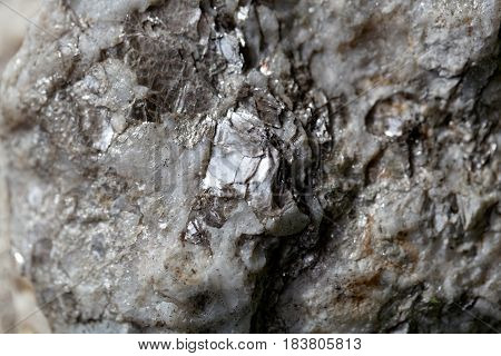 Macro photo of weathered mica minerals in coarse grained quartz rock.