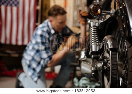 Fixing all the bolts. Masculine mature scrupulous expert being focused while maintaining a bike and enjoying his work