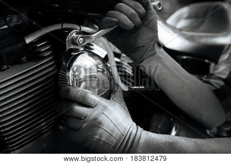 Careful approach. Professional clever capable mechanic tightening up the bolt on vintage bike while fulfilling his job and running a checkup