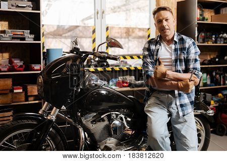All done. Attractive excellent fine repairman telling a client his vehicle being ready after running a checkup and fixing some problems
