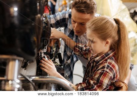 You are doing great. Skillful attentive precise mechanic explaining his child how mechanisms working while giving her a tour at his workplace