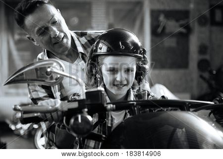 Little biker. Energetic adventurous attentive dad putting a helmet on his childs head for making it feel like a real ride