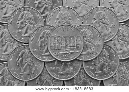 Minnesota State and coins of USA. Pile of the US quarter coins with George Washington and on the top a quarter of Minnesota State.