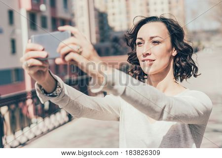 The Girl Poses On The Phone, Photos Herself, Makes A Photo For Social Networks.