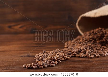 Coffee Is Poured From A Burlap On A Wooden Background