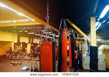 Punching bag in the gym. Against the backdrop of athletes. Gym is a cellar. Pear for boxing.