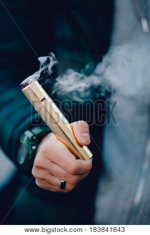 vaping man holding a mod device. cloud of vapor. Vape. Electric cigarettes
