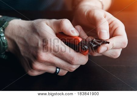 male master installs a coyle. Spiral for electronic evaporator and cigarette. Vape, vaping. Pliers, wire, fichral, coil, screwdriver