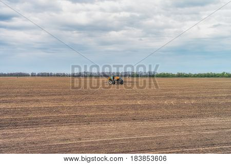 KREMENCHUK, UKRAINE - APRIL 22, 2017: Tractor preparing the field before seeding the ground. Wheat - main crops, which are grown in Ukraine
