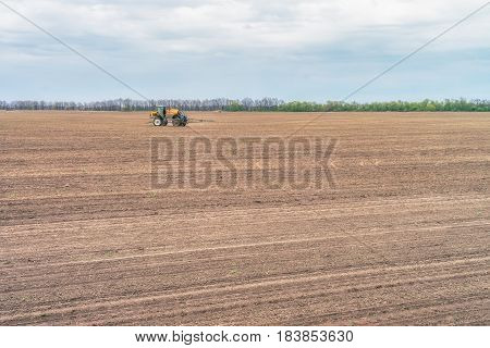 KREMENCHUK, UKRAINE - APRIL 22, 2017: Tractor preparing the field before seeding the ground. Wheat - main crops, which are grown in Ukraine