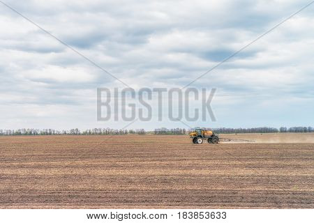 KREMENCHUK, UKRAINE - APRIL 22, 2017: Tractor preparing the field before seeding the ground. Wheat - main crops, which are grown in Ukraine