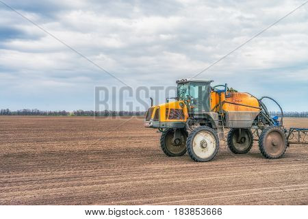 KREMENCHUK, UKRAINE - APRIL 22, 2017: Tractor preparing the field before seeding the ground. Wheat - main crops, which are grown in Ukraine