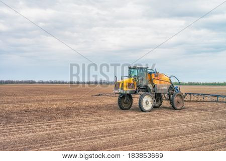 KREMENCHUK, UKRAINE - APRIL 22, 2017: Tractor preparing the field before seeding the ground. Wheat - main crops, which are grown in Ukraine