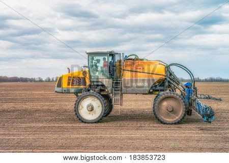 KREMENCHUK, UKRAINE - APRIL 22, 2017: Tractor preparing the field before seeding the ground. Wheat - main crops, which are grown in Ukraine