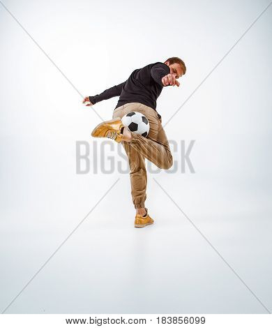 A portrait of a fan with ball on gray studio background. Freestile concept