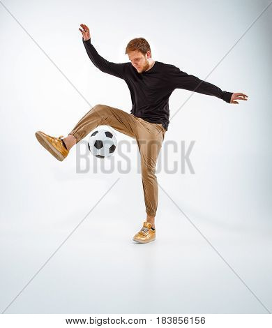 A portrait of a fan with ball on gray studio background. Freestile concept