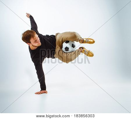 A portrait of a fan with ball on gray studio background. Freestile concept