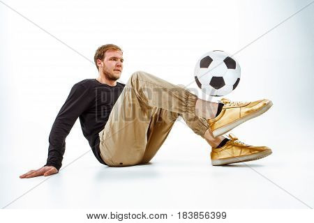 A portrait of a fan with ball on gray studio background. Freestile concept