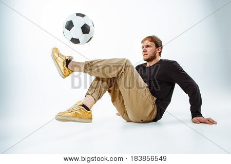A portrait of a fan with ball on gray studio background. Freestile concept