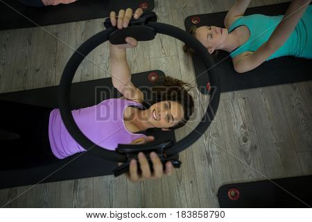 Portrait of fit woman exercising with pilates ring in gym