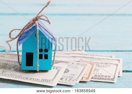 House from the paper and money on wooden background