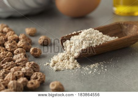 Wooden scoop with tigernut flour and shelled tigernuts