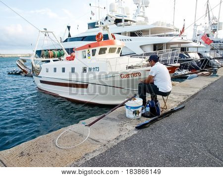Fisherman Sitting At The Port
