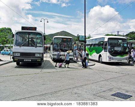 Ngong Ping, Hong Kong - March 24, 2003: Buses and people at the Ngong Ping Bus Terminus on the island of Lantau in Hong Kong