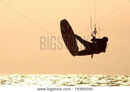 Kitesurfer jumps over the water during training day on Mediterranean sea.