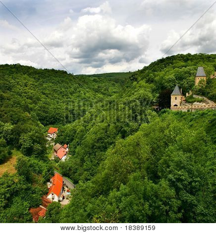 View on green hills and medieval remains of castle in Karlstejn, Czech Republic.