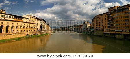 Panoramic view of Arno river among the old houses at sunset in Florence, Italy.