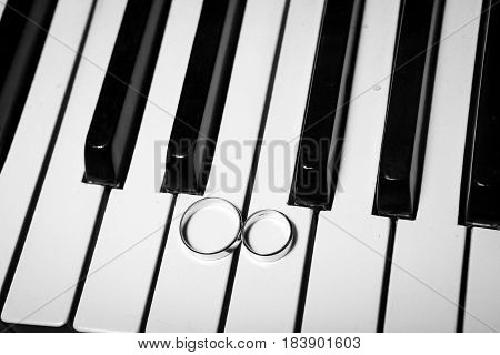 Wedding rings on piano black and white