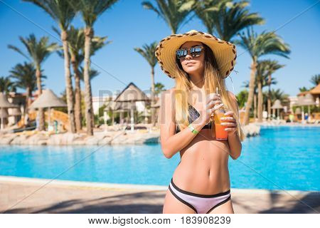 Attractive Smiling Brunette Woman In Summer With Cocktail And Straw Hat Near Swim Pool