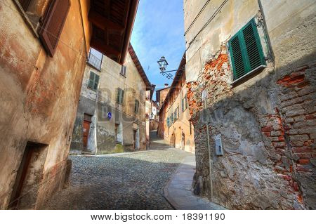 Schmalen gepflasterten Straße zwischen alten historischen Häusern in Saluzzo, Norditalien.