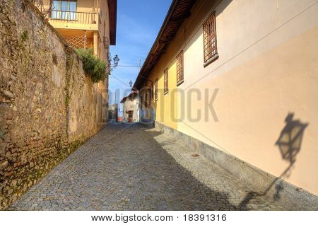 Schmalen gepflasterten Straße zwischen den alten Häusern und Wand in Stadt Saluzzo, Norditalien.