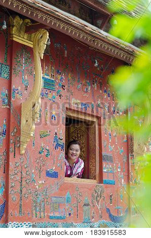 LUANGPRABANG LAOS: APRIL 22 2017 - woman on the buddhist church smiling at Wat Xieng thong temple world heritage on Aril 222017 Luang Pra bang Laos