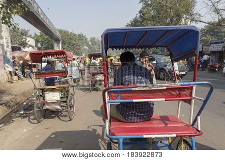DELHI INDIA - NOV 2 : rickshaw driver waiting for passengers near new delhi railway station. this three wheeler bike is taxi in delhi on november 2 2014 india