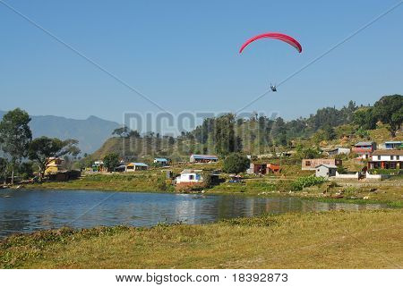 atterrare con un paracadute dopo parapendio nei pressi di un lago in nepal