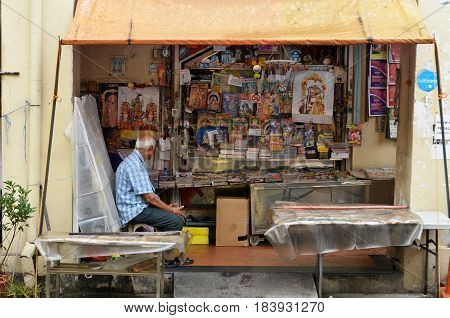 SINGAPORE- APR 09 2017: Owner of Indian magazines store along at the roadside of Little India in Singapore Little India is Singaporean neighborhood east of the Singapore River