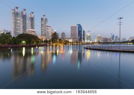 City office building view with refleciton over public park lake cityscape background