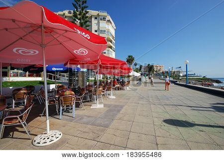 TORROX COSTA, SPAIN - OCTOBER 27, 2008 - Tourists walking along the promenade with pavement cafes to the left hand side Torrox Costa Malaga Province Andalusia Spain Western Europe, October 27, 2008.