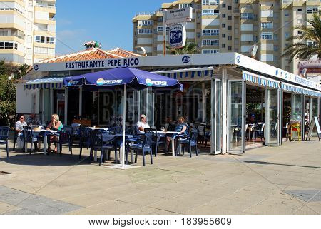TORROX COSTA, SPAIN - OCTOBER 27, 2008 -Tourists relaxing at a restaurant along the promenade Torrox Costa Malaga Province Andalusia Spain Western Europe, October 27, 2008.