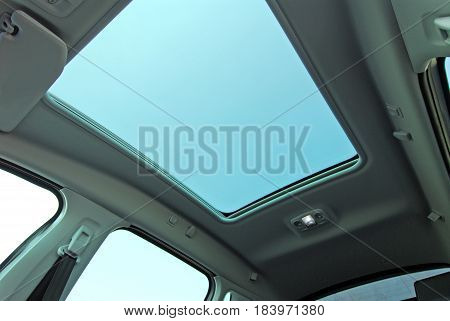 photo large sunroof inside car, sky and clouds