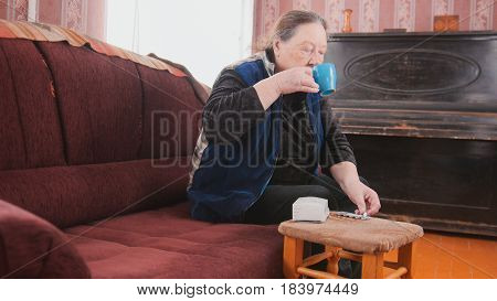 Senior lady - elderly woman at home drinking from a mug - pension life, midle shot